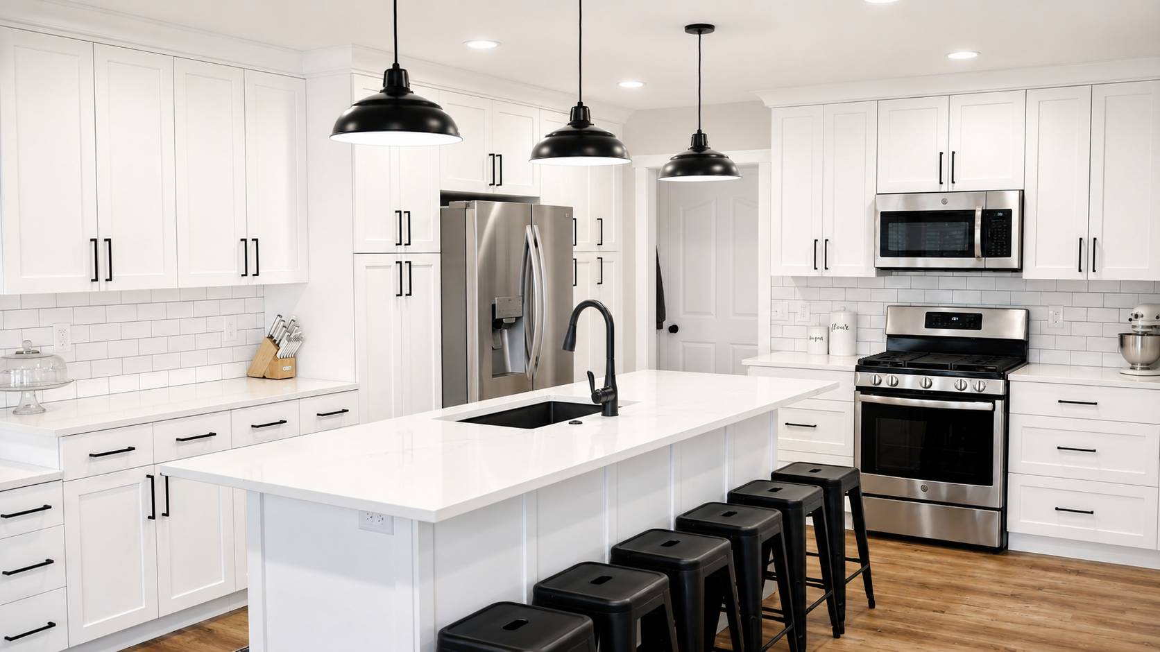 Modern farmhouse kitchen with black pendants and a white island